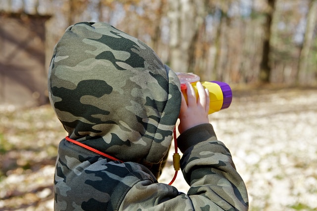 kid with binoculars hiking in backcountry